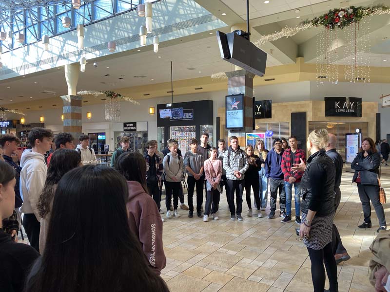 High School students listening to presentation in mall