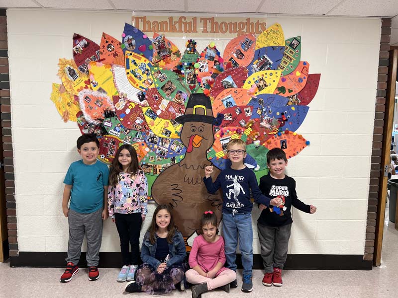 Students posing in front of cutout Turkey which they designed