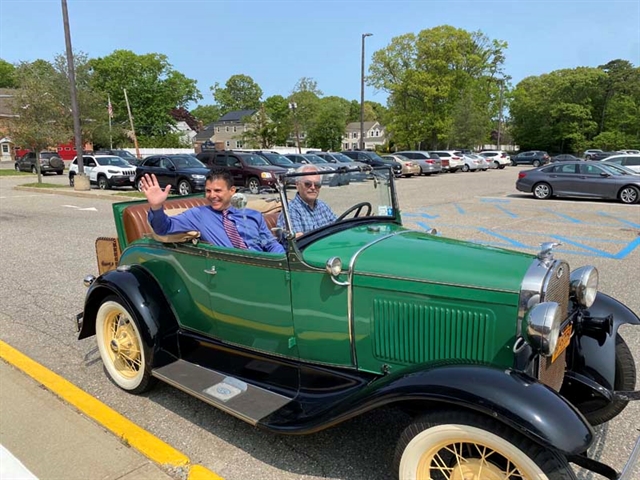 Principal driving in a old car