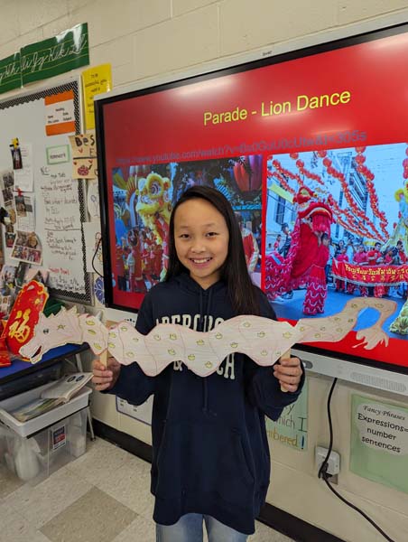 Student holding paper dragon