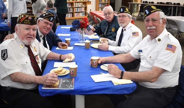 Veterans smiling at table