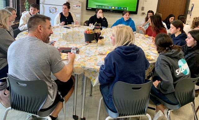 Students and faculty eating at table