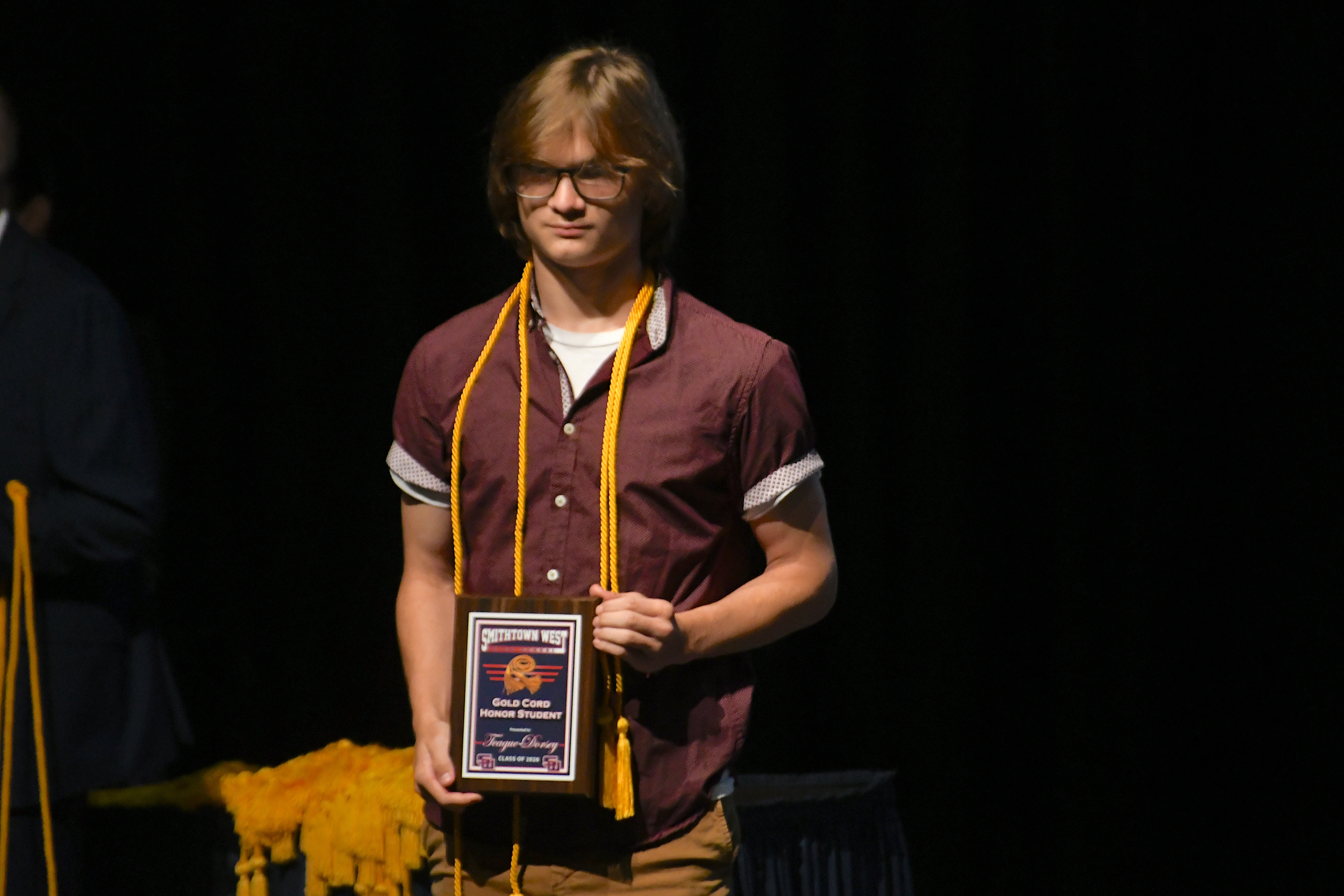 Student smiling holding plaque