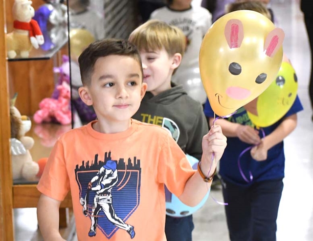 Students holding balloons in parade