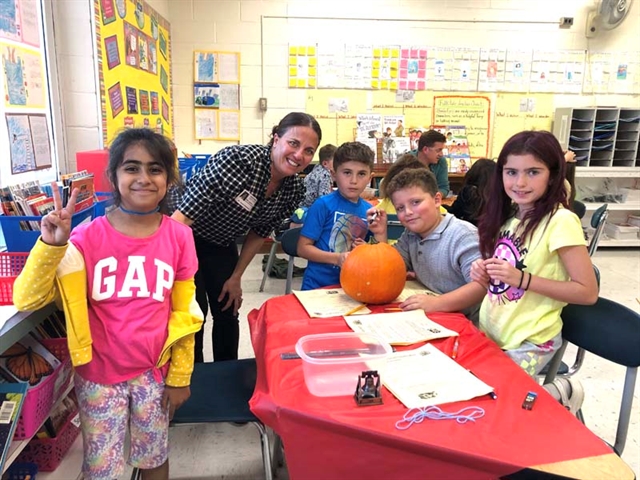 students and parents carving out pumpkins