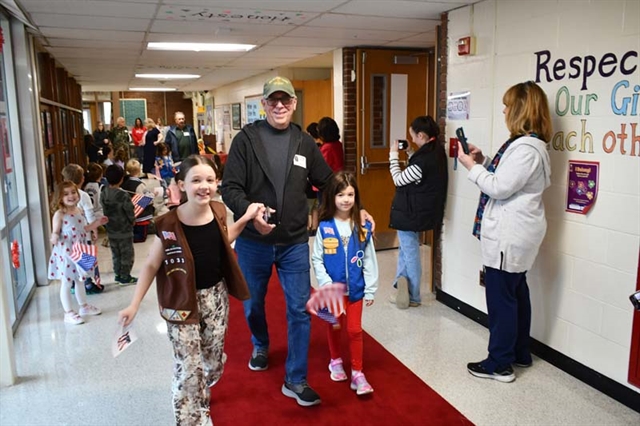 Veteran walking down aisle with student