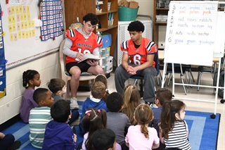 players reading to students