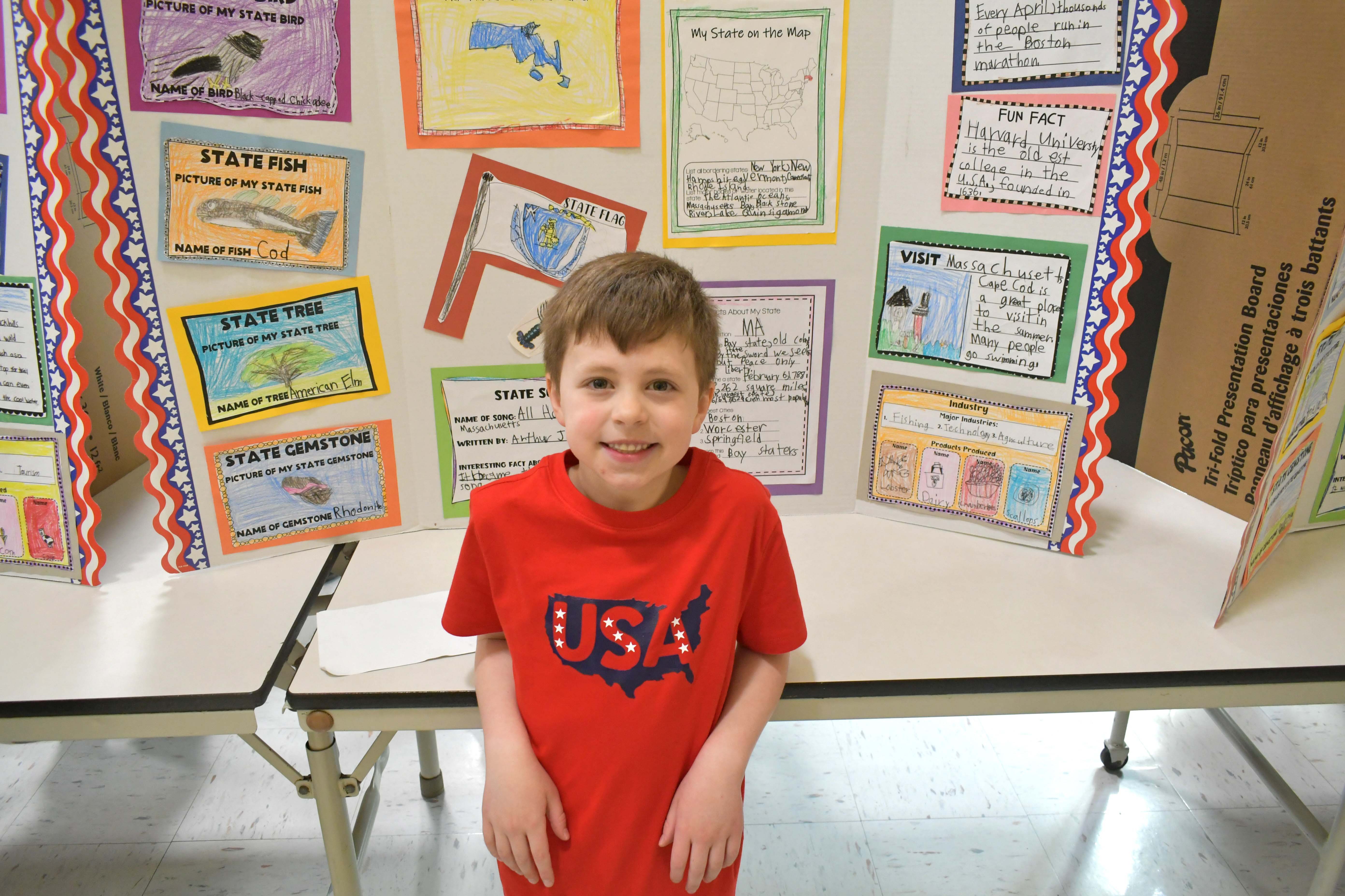 Student smiling in front of sign