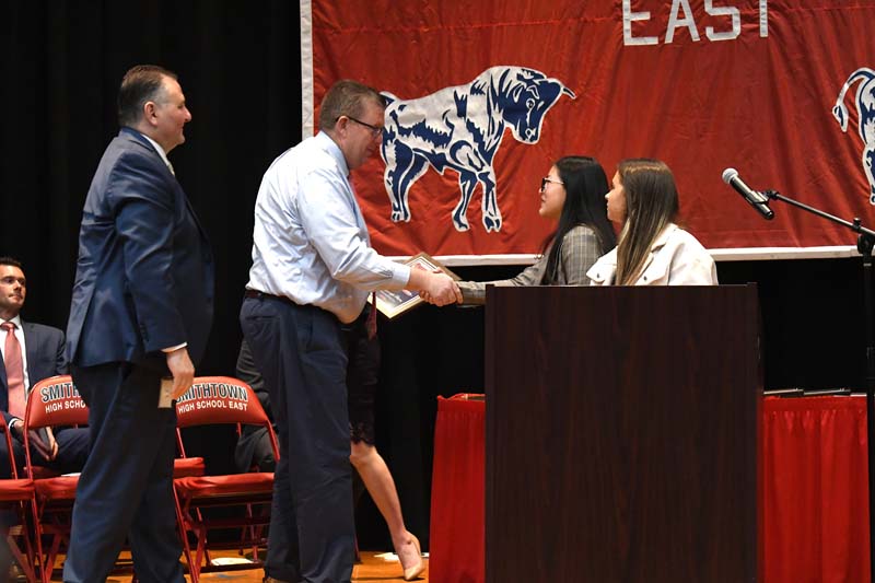 Superintendent Secaur shaking hands with student