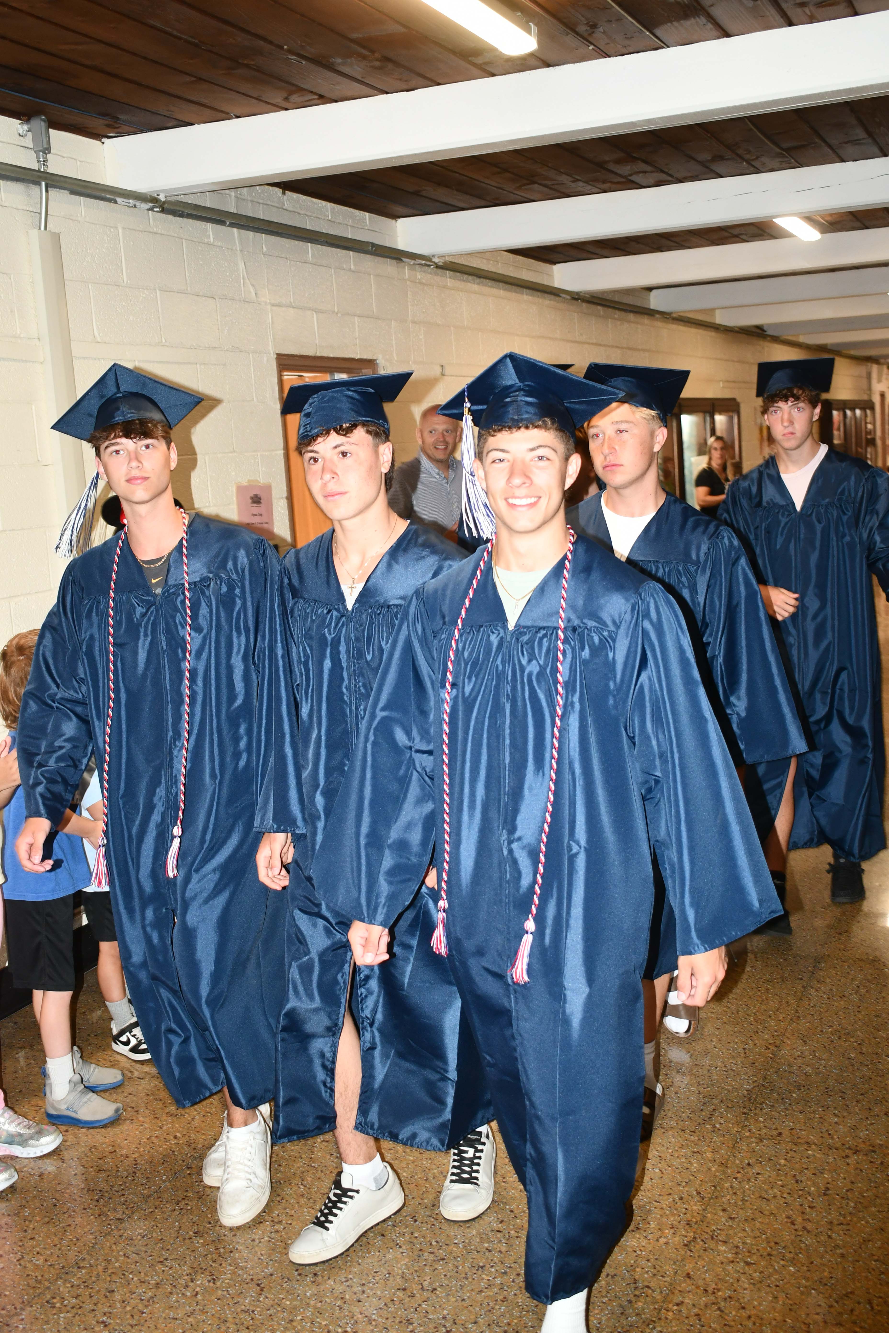 Students walking down the hallway in caps and gowns