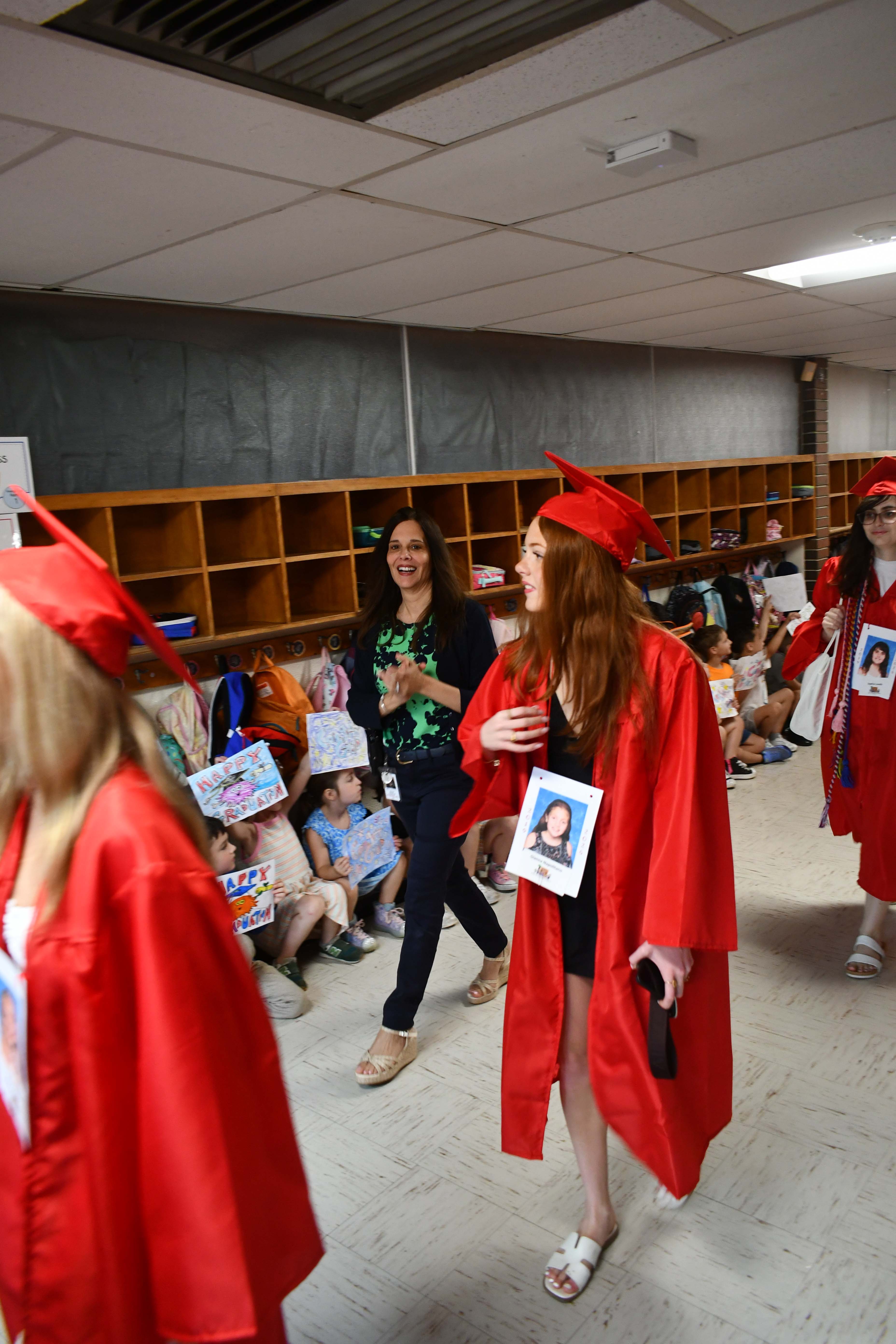 Students walking down the hallway in caps and gowns