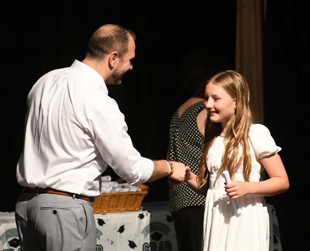 Principal shaking hands with student