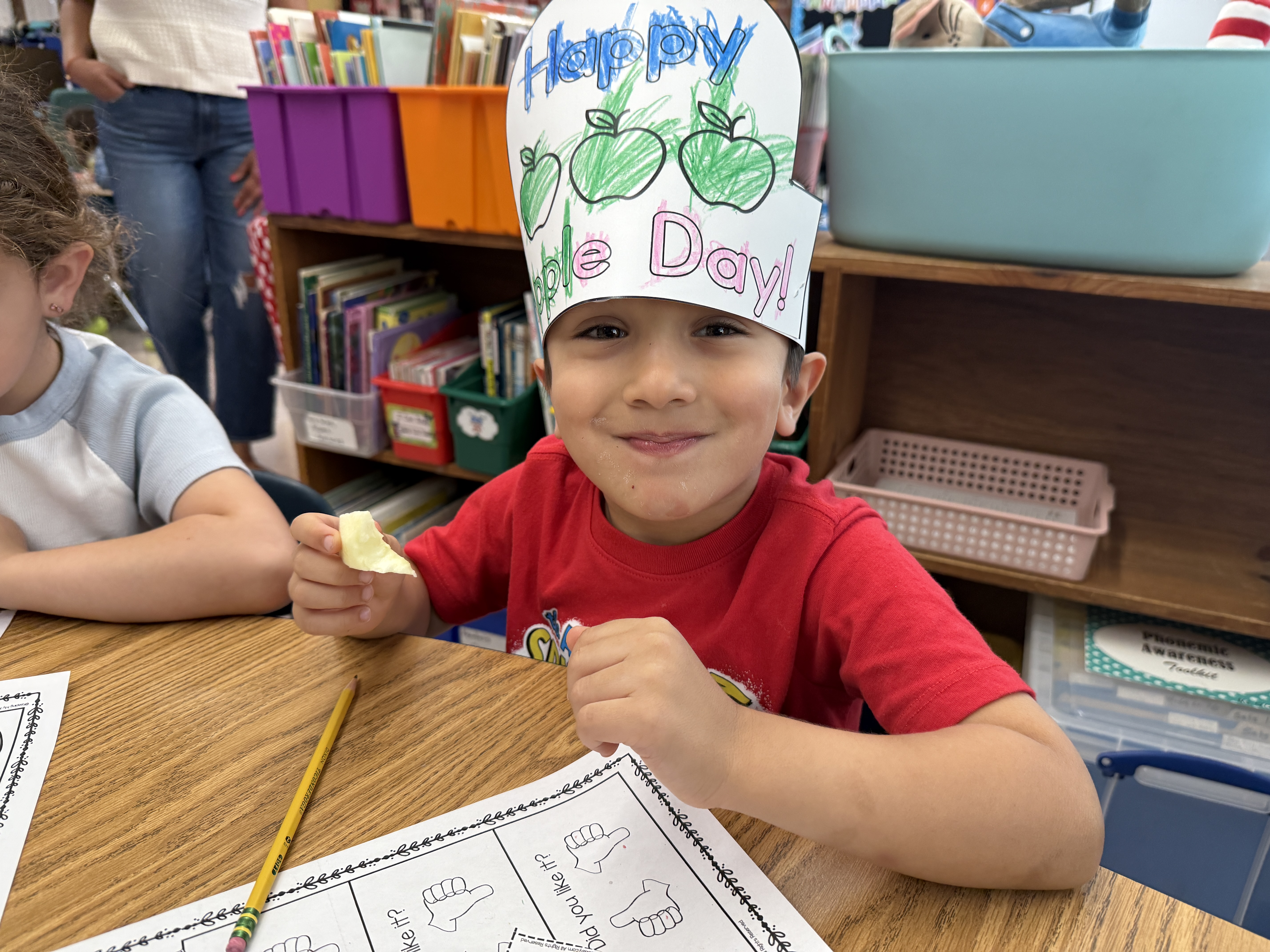 student wearing apple hats and smiling