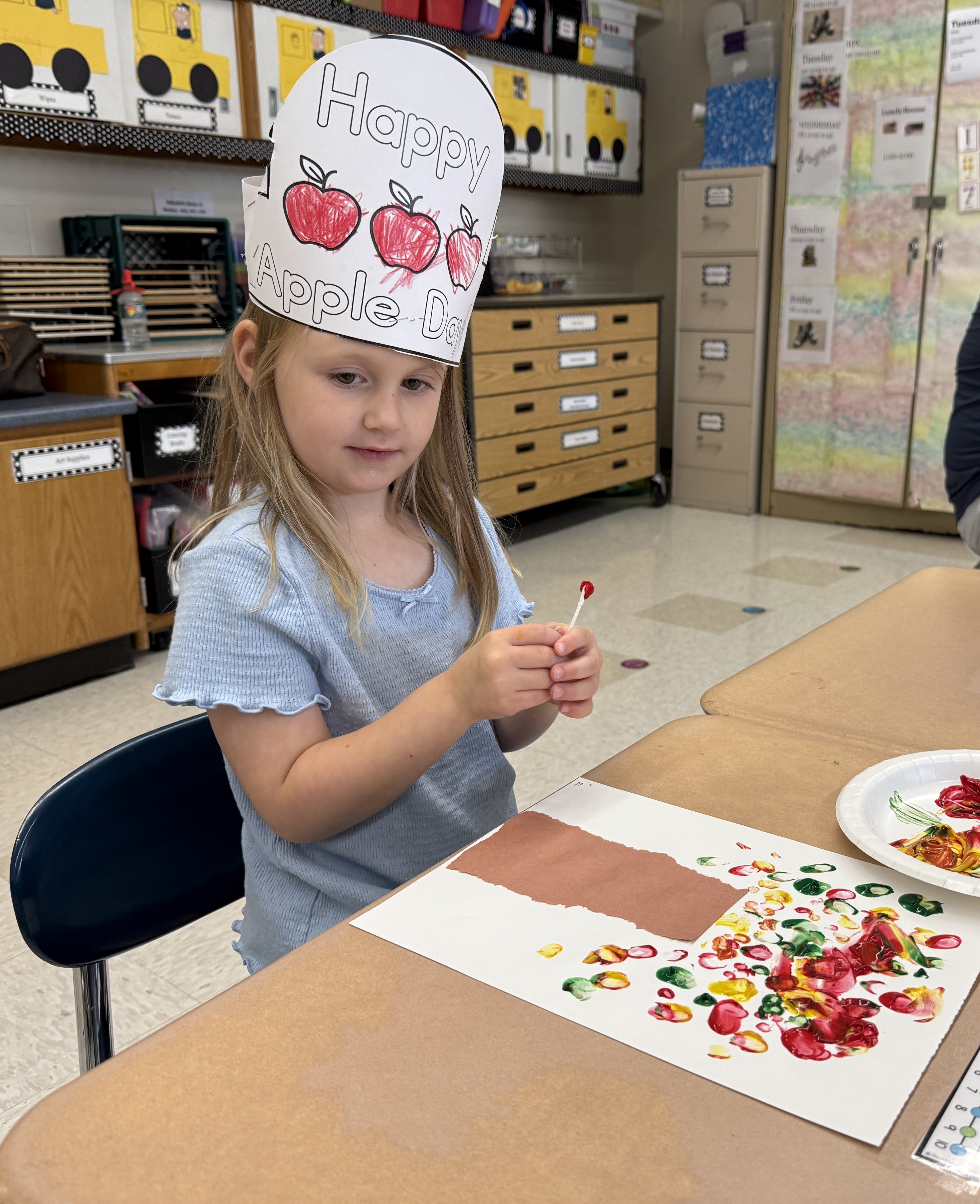 student wearing apple hats and smiling