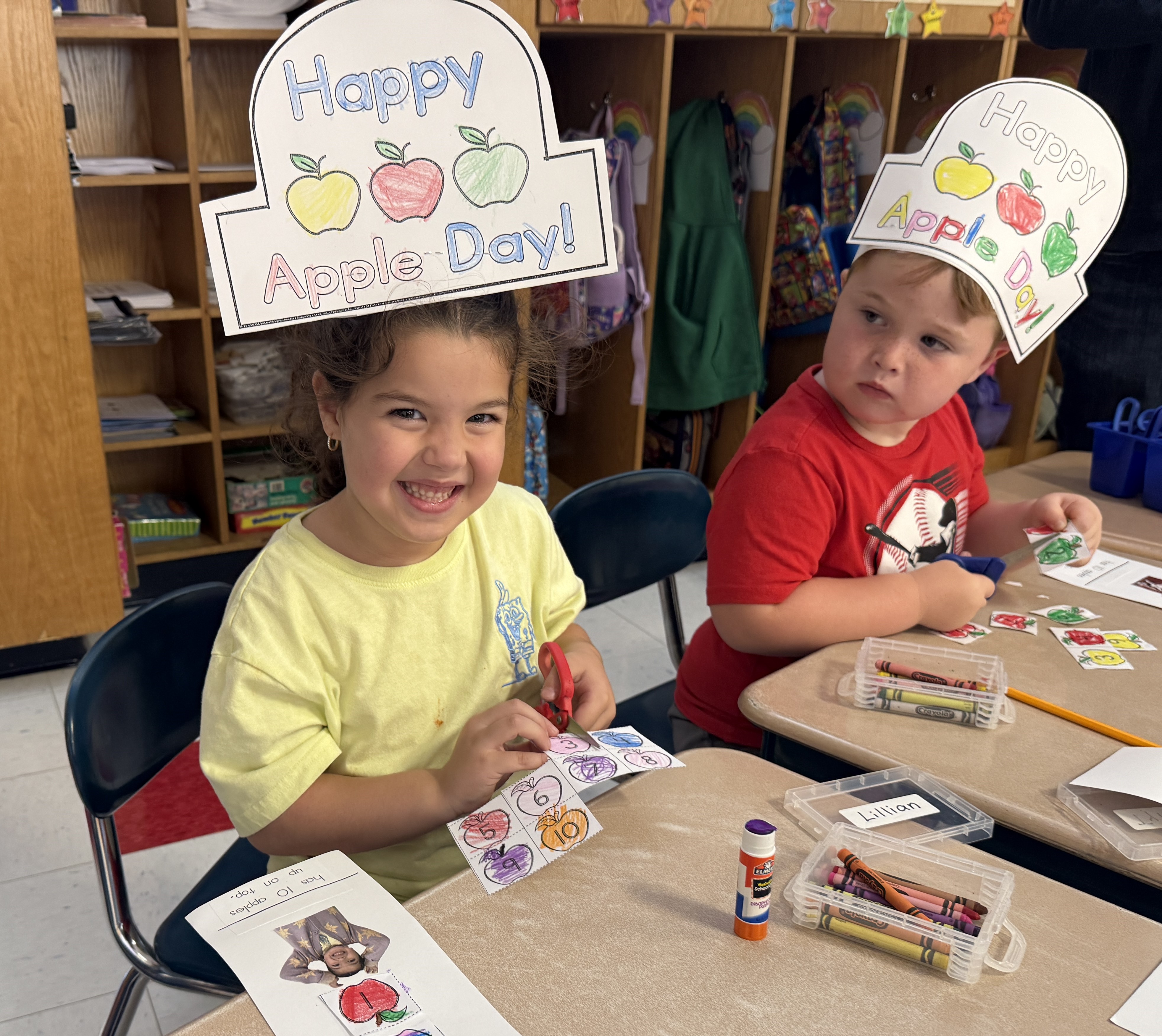 students wearing apple hats and smiling