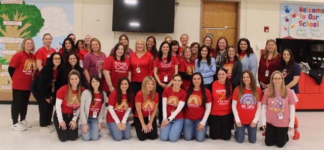 Students and staff wearing red posing for a picture