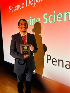 student holding award