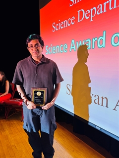 student holding award