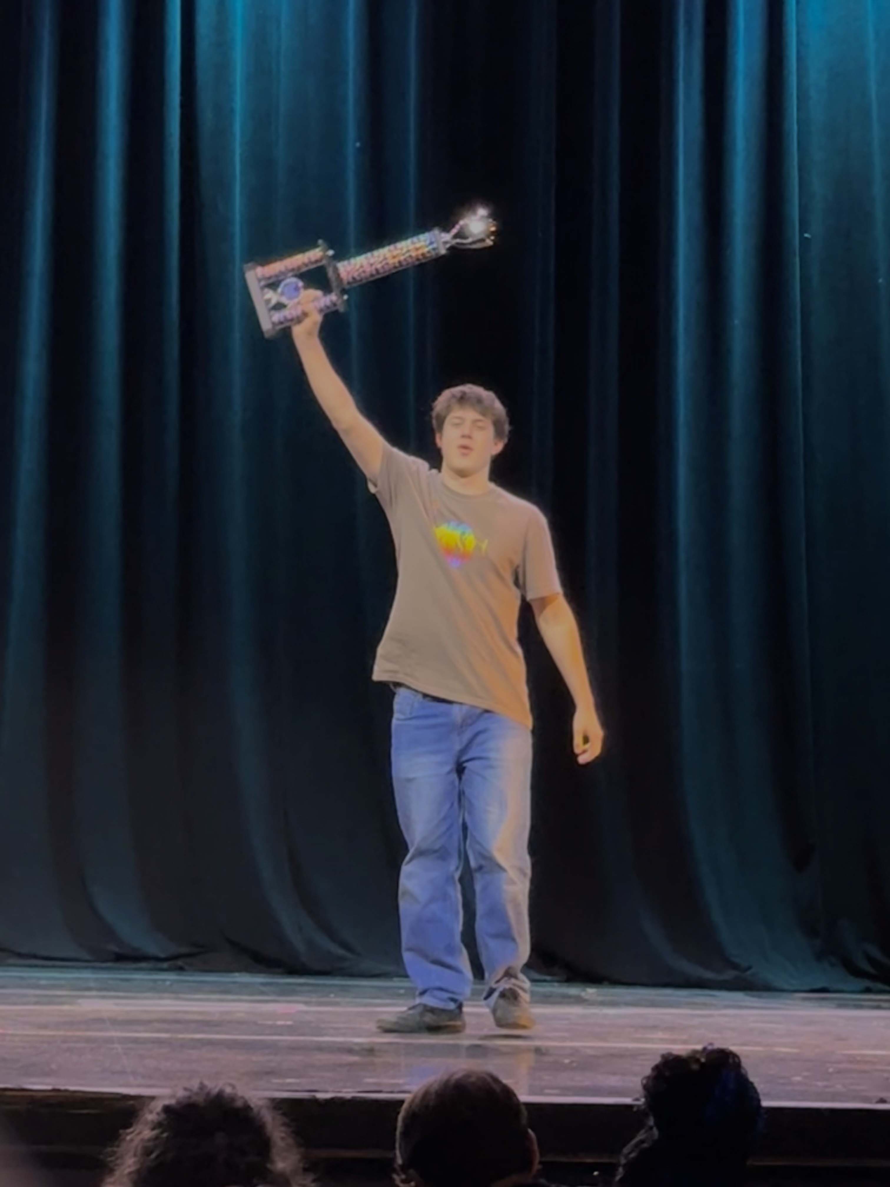 student on stage with award