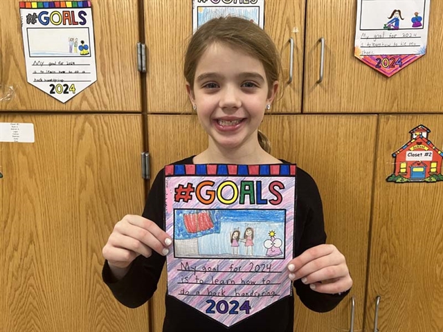 student holding a sign for New Year's goal