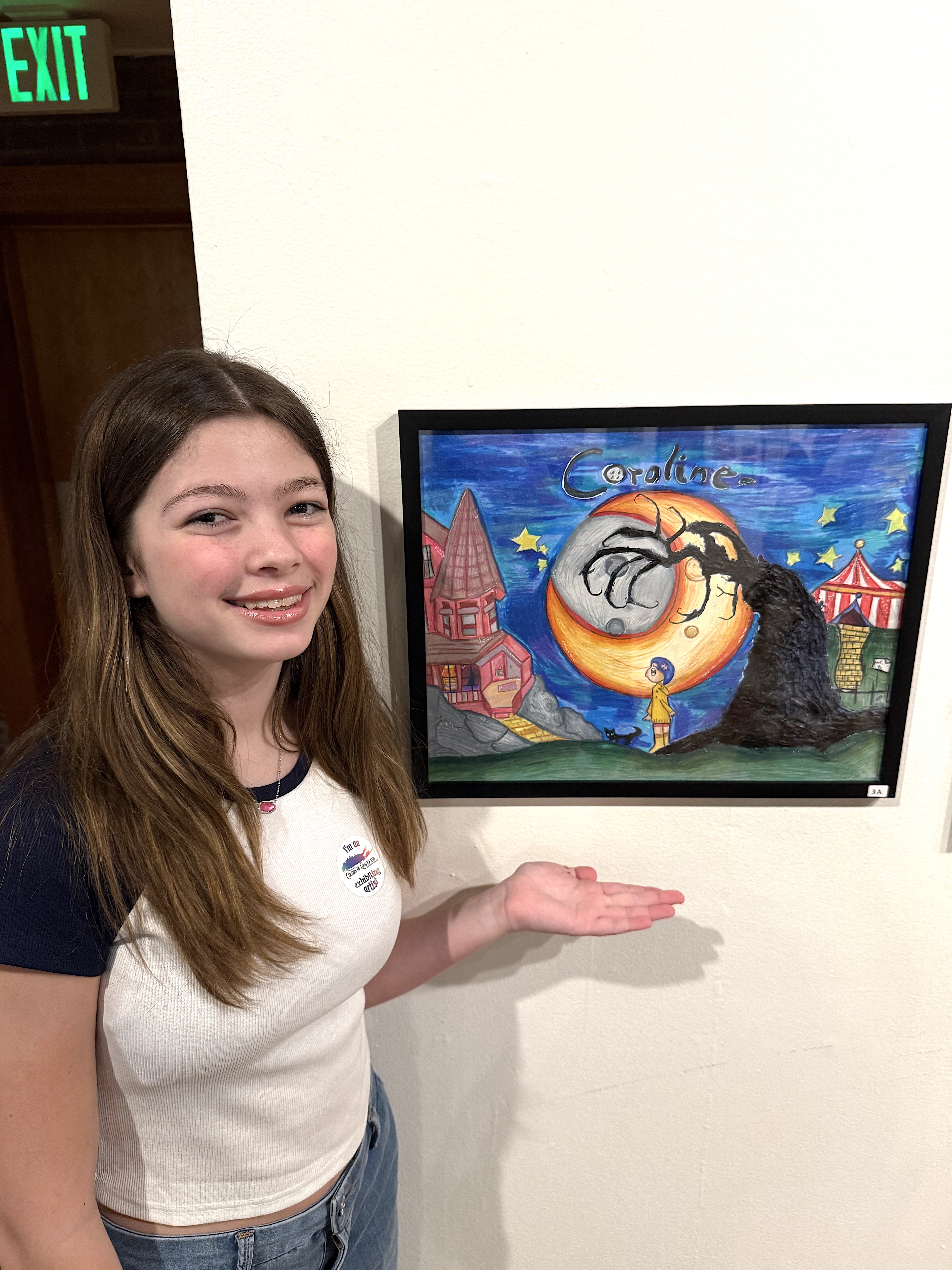 Student posing with artwork