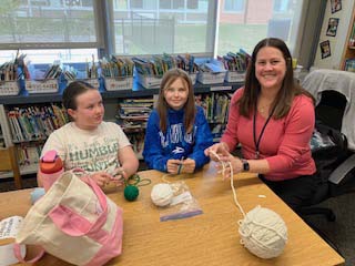 students and teacher crocheting