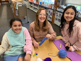 students and teacher crocheting
