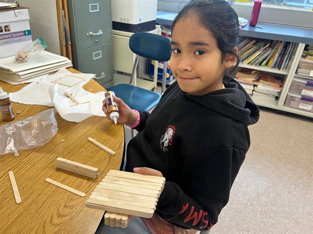 Student with popsicle bridge