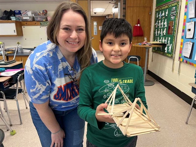 Student with popsicle bridge