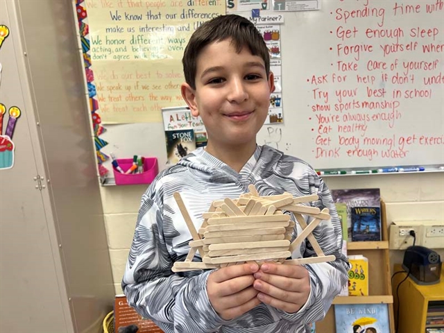 Student with popsicle bridge