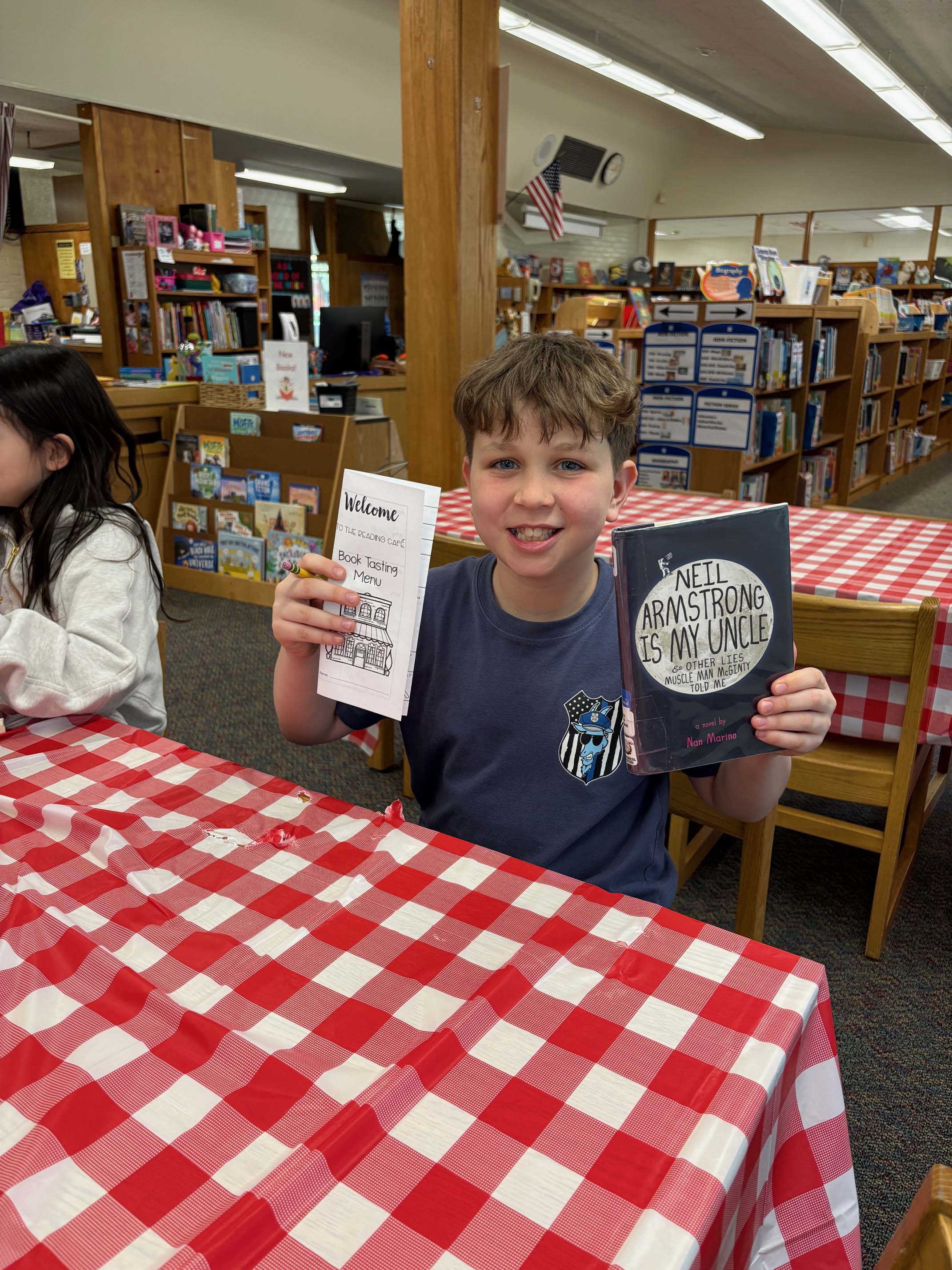 student holding up book