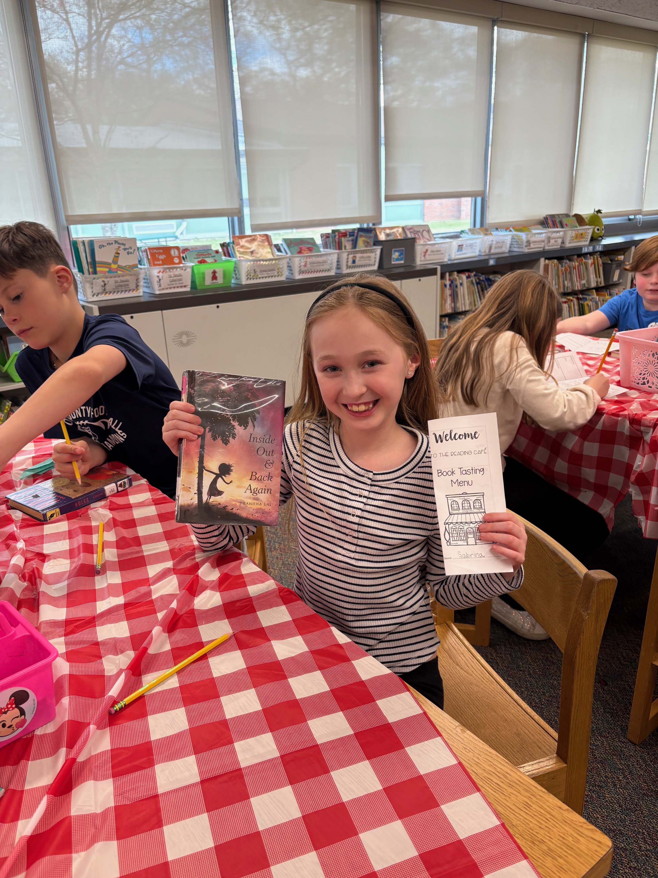 student holding up book