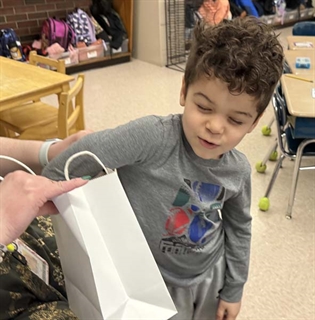 Student reaching in a bag