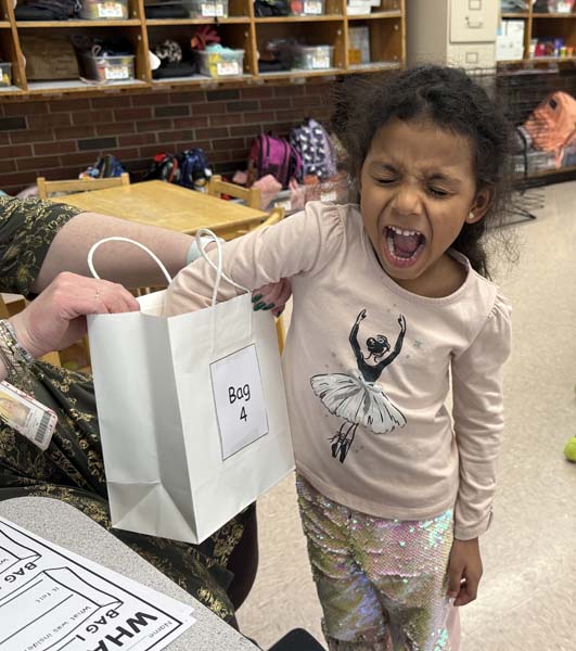 Student reaching in a bag