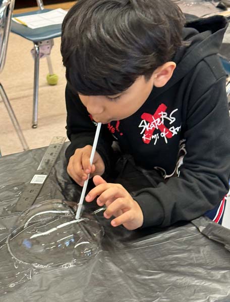 student blowing bubbles