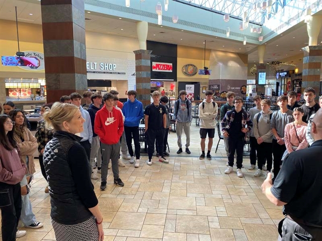 High School students listening to presentation in mall