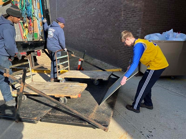 student loading clothes on truck