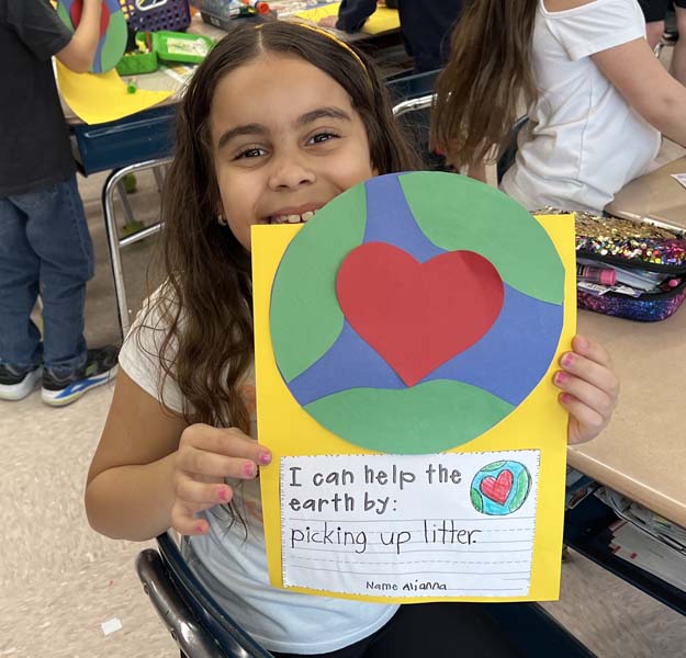 student holding up earth day sign