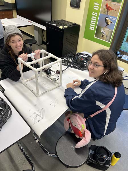 Students holding underwater robot