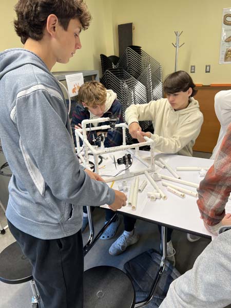 Students holding underwater robot