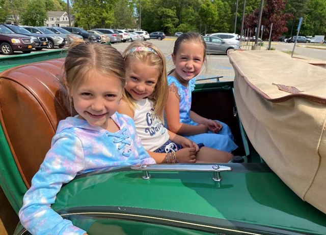 students posing by an old car