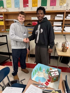 students smiling and shaking hands