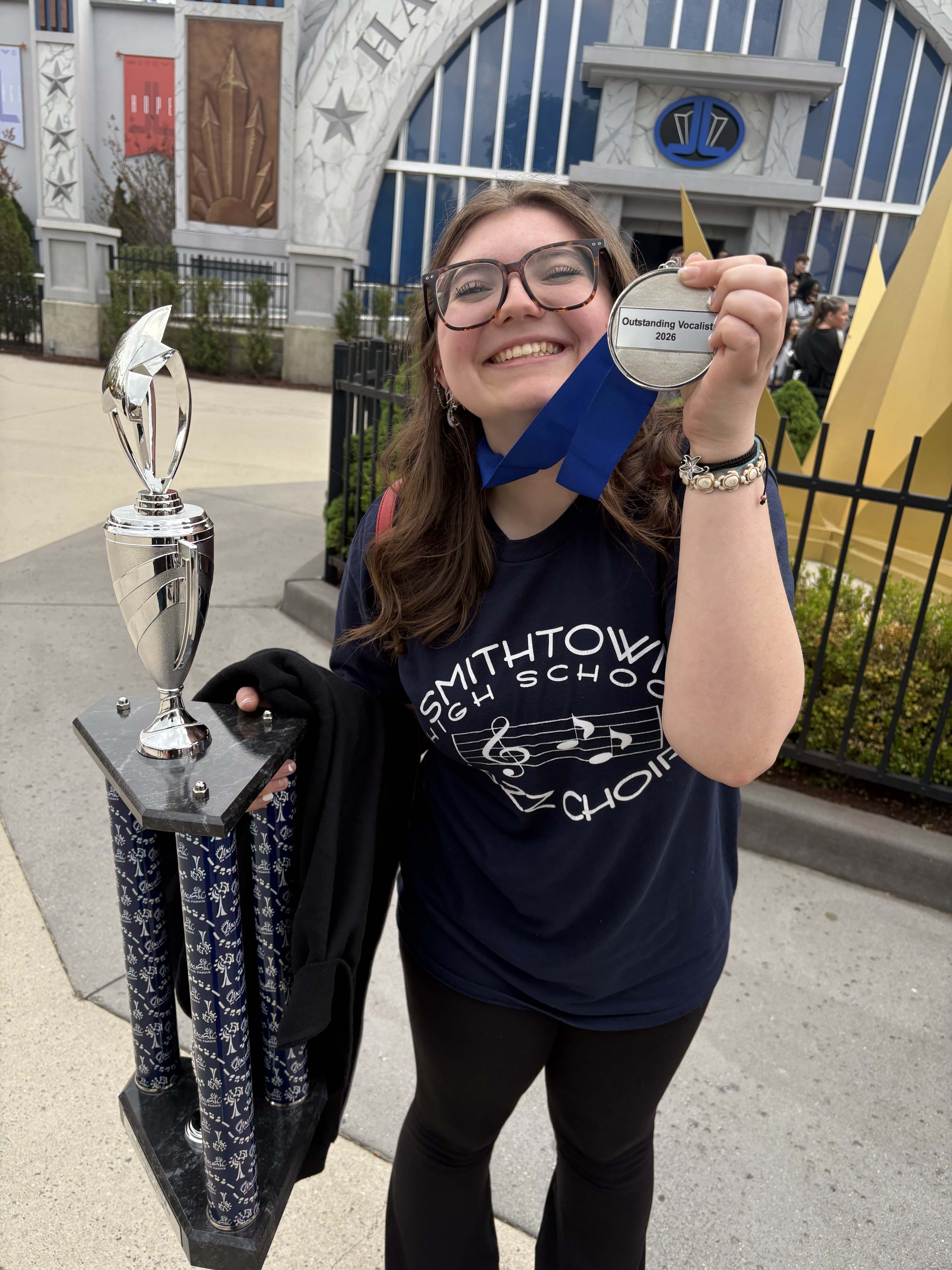 student smiling with award