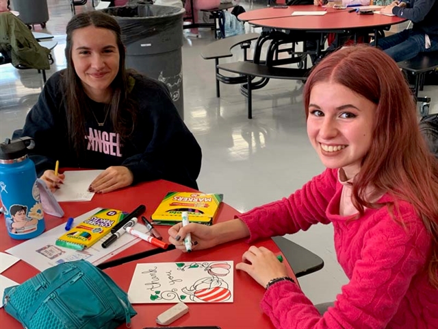 High School students smiling with cards for Veterans