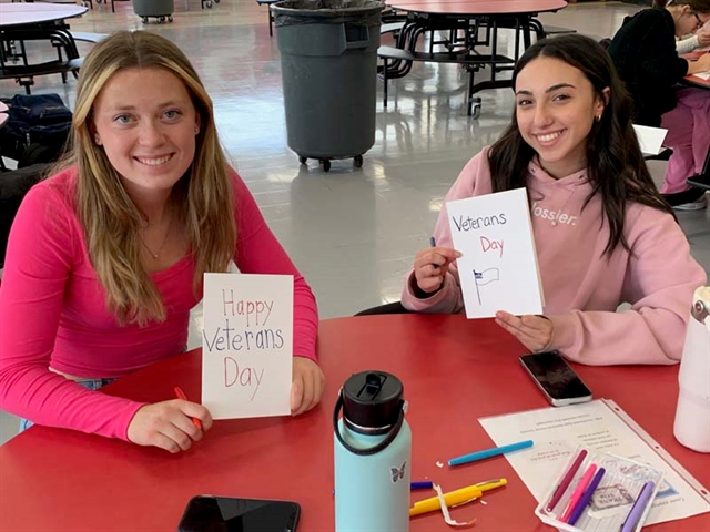 High School students smiling with cards for Veterans