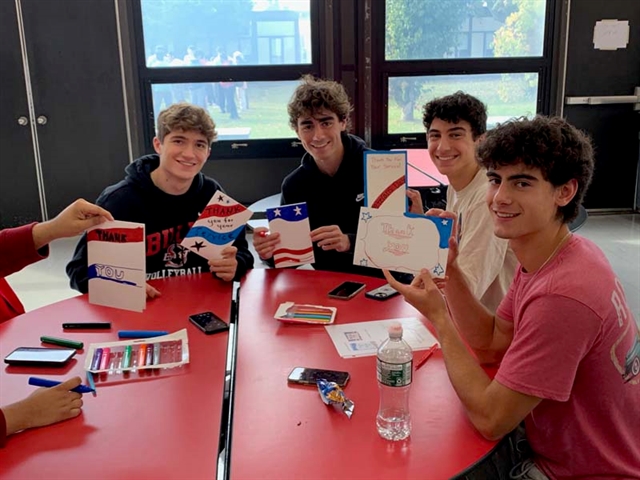 High School students smiling with cards for Veterans