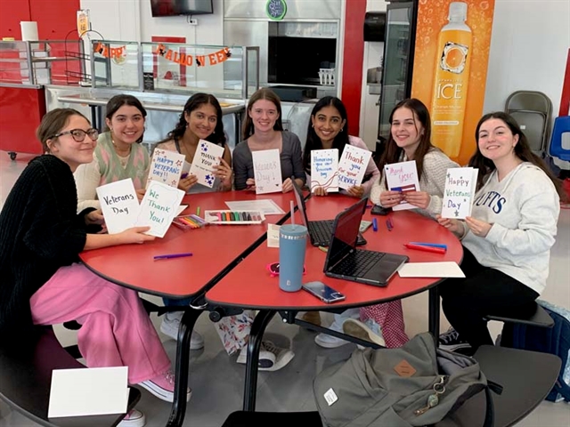 High School students smiling with cards for Veterans