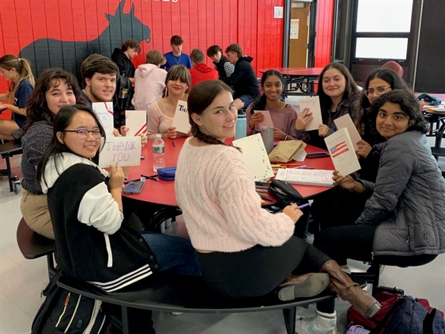 High School students smiling with cards for Veterans