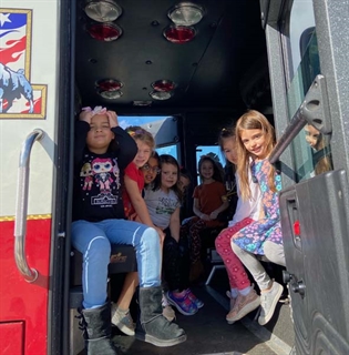 students smiling on fire truck