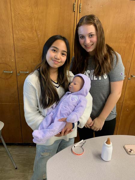 High School student holding a computerized baby